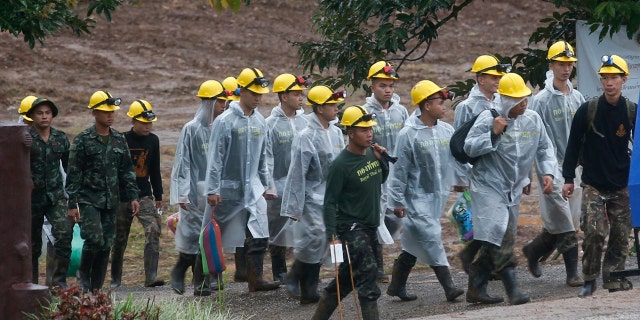 Rescuers walk toward the entrance to a cave complex where five were still trapped, in Mae Sai, Chiang Rai province, northern Thailand Tuesday, July 10, 2018.