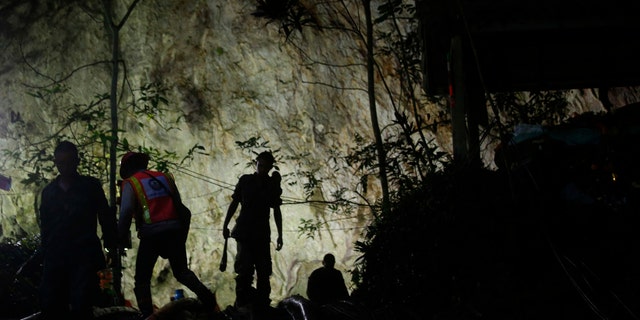 Rescuers make their way down at the entrance to a cave complex where 12 boys and their soccer coach went missing, in Mae Sai, Chiang Rai province, in northern Thailand.