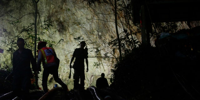 Rescuers make their way down at the entrance to a cave complex where 12 boys and their soccer coach went missing, in Mae Sai, Chiang Rai province, in northern Thailand.