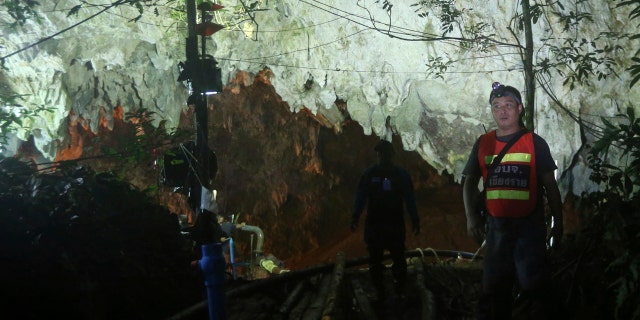 A rescuer stands in front of the entrance to a cave complex where 12 boys and their soccer coach went missing, in Mae Sai, Chiang Rai province, in northern Thailand.