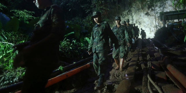 Rescuers make their way down at the entrance to a cave complex where 12 boys and their soccer coach went missing, in Mae Sai, Chiang Rai province, in northern Thailand, Sunday, July 1, 2018.