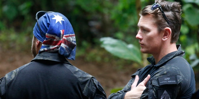 Australian Federal Police and Defense Force personnel talk each other near a cave complex where 12 boys and their soccer coach went missing, in Mae Sai, Chiang Rai province, in northern Thailand, Sunday, July 1, 2018.