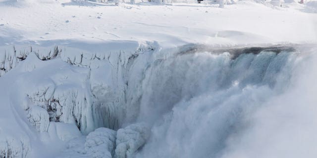 Niagara Falls State Park visitors look over masses of ice formed around the American Falls, photographed from across the Niagara River in Niagara Falls, Ontario, Canada, Thursday, Feb. 19, 2015. (AP Photo/The Canadian Press,Aaron Lynett)