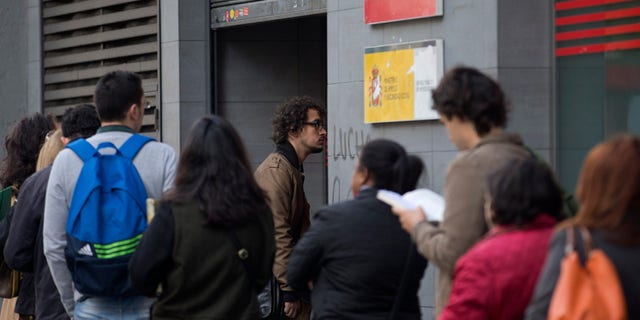 People queue to enter a government unemployment office in Madrid, Spain, Tuesday Oct. 5, 2013. The number of people registered as unemployed in Spain rose by a little over 87,000 in October as many jobs created in the summer tourist season come to an end. The increase comes amid some hopeful signs over Spain's economy with a two-year recession coming to an end in the third quarter, albeit with modest quarterly growth of 0.1 percent. (AP Photo/Paul White)