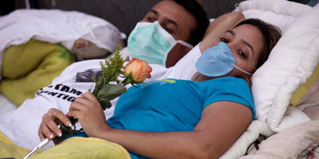 Los estudiantes Isli Lugo, al frente, que sostiene una flor, y German Cortez, aparecen en Caracas, Venezuela, el martes 15 de febrero de 2011, durante una huelga de hambre que desde el 31 de enero llevan adelante unos 12 estudiantes que buscan que la Organización de los Estados Americanos, OEA, investigue denuncias de violaciones de los derechos humanos de parte del gobierno del presidente venezolano Hugo Chávez. (AP Photo/Ariana Cubillos)