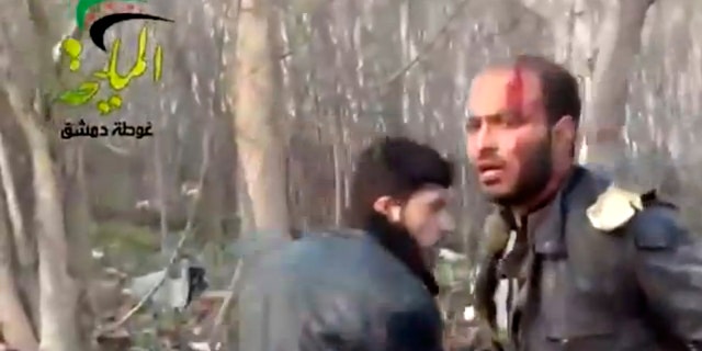 This citizen journalism image taken from video provided by Shaam News Network, which has been authenticated based on its contents and other AP reporting, shows a wounded man at the site of a Syrian government airstrike on a gas station in the eastern Damascus suburb of Mleiha, Syria, Wednesday, Jan. 2, 2013. Activists say dozens of people have been killed or wounded in an air raid on a gas station near the capital Damascus. (AP Photo/Shaam News Network via AP video)