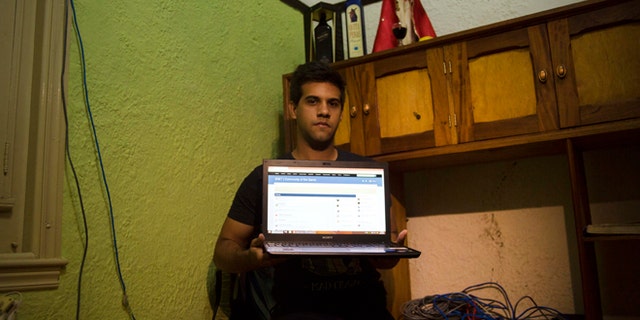 Rafael Antonio Broche Moreno with his computer, modem and intranet network cabling at his home in Havana.