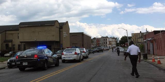Authorities are on scene outside of a church hall in west Baltimore, Tuesday, June 7, 2016, where Baltimore police say a man shot his father at a post-funeral repast for his brother.