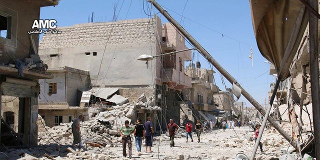 FILE - n this Wednesday, July. 27, 2016 photo, provided by the Syrian anti-government activist group Aleppo Media Center (AMC), shows Syrian citizens inspect damaged buildings after airstrikes hit Aleppo, Syria.