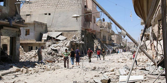 FILE - n this Wednesday, July. 27, 2016 photo, provided by the Syrian anti-government activist group Aleppo Media Center (AMC), shows Syrian citizens inspect damaged buildings after airstrikes hit Aleppo, Syria.