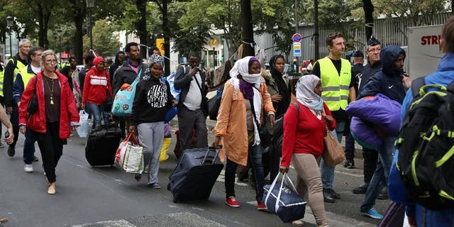 Migrants are evacuated from a camp in the north of Paris, Friday, Sept. 16, 2016. Police and city officials are evacuating hundreds of migrants who had been living on the streets of northern Paris for weeks, in the latest of a string of attempts to find solutions for France's migrants. (AP Photo/Thibault Camus)