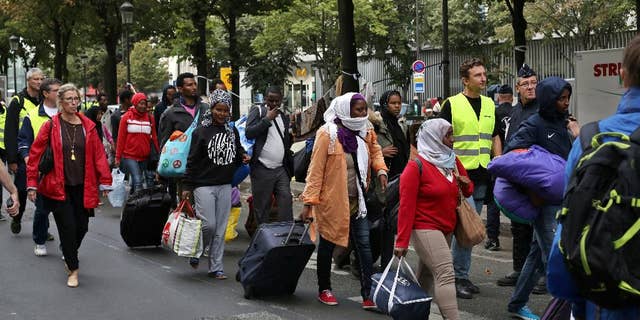 Migrants are evacuated from a camp in the north of Paris, Friday, Sept. 16, 2016. Police and city officials are evacuating hundreds of migrants who had been living on the streets of northern Paris for weeks, in the latest of a string of attempts to find solutions for France's migrants. (AP Photo/Thibault Camus)