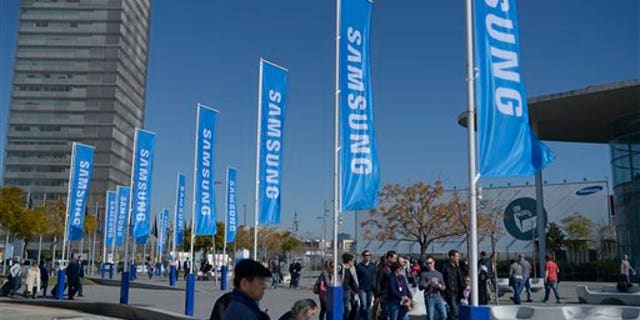 Visitors walk outside the Mobile World Congress, the world's largest mobile phone trade show, in Barcelona, Spain, Sunday, Feb. 23, 2014. (AP Photo/Manu Fernandez)