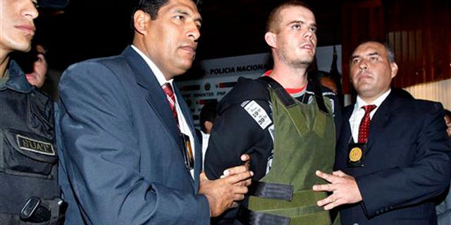 June 5, 2010: Police officers escort Joran van der Sloot, second right, during a press conference at a police station in Lima, Peru.