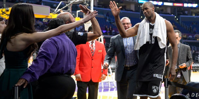 Brooklyn Nets center Jason Collins, right, is congratulated by fans after they defeated the Los Angeles Lakers in an NBA basketball game, Sunday, Feb. 23, 2014, in Los Angeles. Brooklyn won 108-102. (AP Photo/Mark J. Terrill)