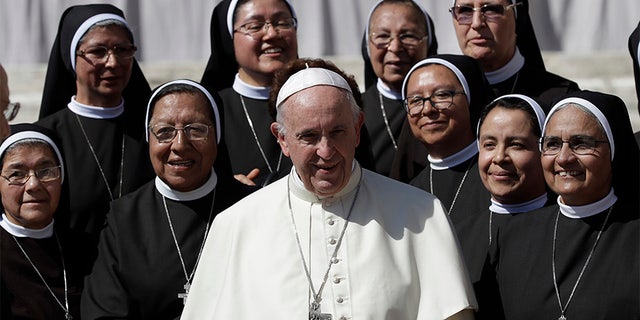 Pope Francis poses for a photo with nuns at the end of his general audience in St. Peter's Square at the Vatican Wednesday.