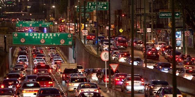 FILE - In this March 30, 2016, file photo, cars sit in evening rush hour traffic in Mexico City. Under rules that took effect Tuesday, April 5, 2016, and with the city heading into a second day of a pollution alert, authorities ordered 40 percent of cars to stay home Wednesday. The ban covers over 2 million cars in the metropolitan area, which has about 20 million residents. (AP Photo/Rebecca Blackwell, File)