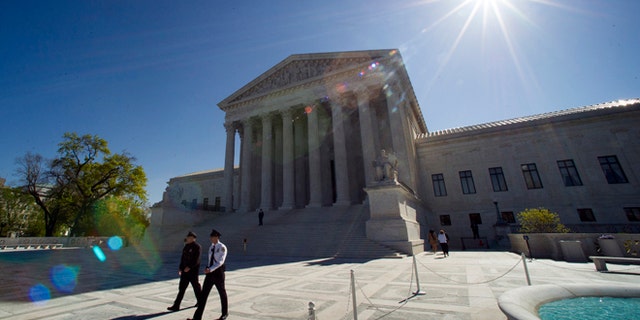 Supreme Court police officers walk on the plaza in front of the Supreme Court in Washington, Tuesday, April 28, 2015. The Supreme Court is set to hear historic arguments in cases that could make same-sex marriage the law of the land. The justices are meeting Tuesday to offer the first public indication of where they stand in the dispute over whether states can continue defining marriage as the union of a man and a woman, or whether the Constitution gives gay and lesbian couples the right to marry. (AP Photo/Cliff Owen)