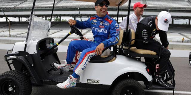 Tony Kanaan, of Brazil, laughs as Sage Karam looks at a flat tire on the cart they where riding in before the start of practice for the Indianapolis 500 auto race at Indianapolis Motor Speedway in Indianapolis, Monday, May 18, 2015. (AP Photo/Michael Conroy)