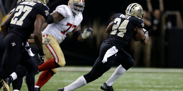 New Orleans Saints cornerback Corey White (24) carries an interception as San Francisco 49ers guard Mike Iupati (77) pursues in the first half of an NFL football game in New Orleans, Sunday, Nov. 17, 2013. (AP Photo/Dave Martin)