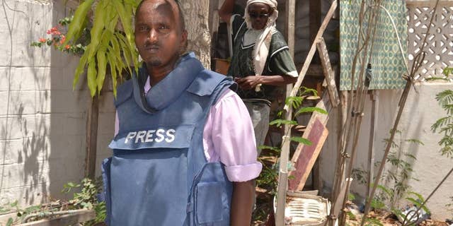 In this photo taken Saturday, March 22, 2014, Somali journalist Abdiaziz Mohamed Ali Haji, ,left, stands in radio Shabelle compound in Mogadishu, Somalia. Abdiaziz Mohamed Ali Haji, a reporter for Shabelle radio, was shot dead by unidentified gunmen on his way to home in the north of the capital city, said Abdirizak Turyare, a producer at the radio station. (AP Photo/Farah Abdi Warsameh,)