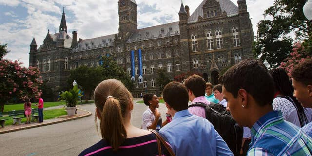FILE - In this July 10, 2013, file photo, prospective students tour Georgetown University's campus in Washington, D.C. (AP Photo/Jacquelyn Martin, File)