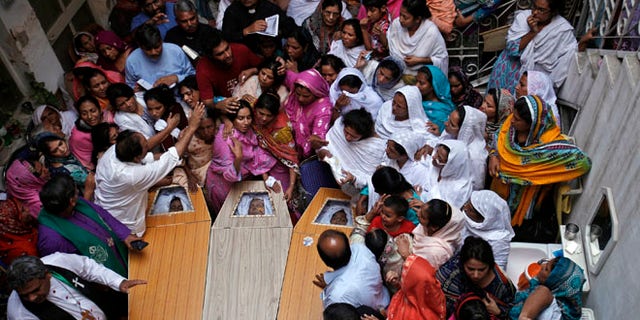 Sept. 24, 2013: Pakistani Christians mourn in a family home as they gather around the coffins of their relatives, who were killed in Sunday's suicide attack on a church, in Peshawar.