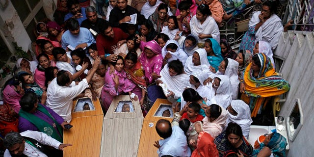 Sept. 24, 2013: Pakistani Christians mourn in a family home as they gather around the coffins of their relatives, who were killed in Sunday's suicide attack on a church, in Peshawar.
