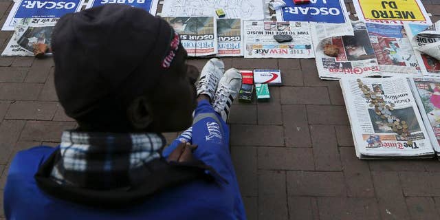 A vendor sells newspaper with headlines on Oscar Pistorius ouside the high court in Pretoria, South Africa, Tuesday, April 8, 2014. Pistorius, who is charged with murder for the shooting death of his girlfriend, Reeva Steenkamp, on Valentines Day in 2013, was testifying for a second day at his murder trial Tuesday, answering questions from his defense lawyer. (AP Photo/Themba Hadebe)