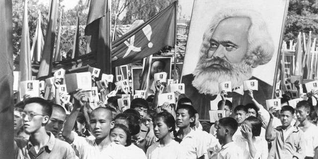 Demonstrators in China wave copies of Mao Zedong's Little Red Book while carrying a poster of Karl Marx during a rally on Sept. 14, 1966.