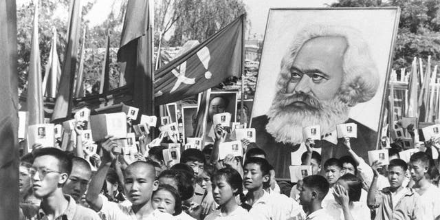 Demonstrators in China wave copies of Mao Zedong's Little Red Book while carrying a poster of Karl Marx during a rally on Sept. 14, 1966.