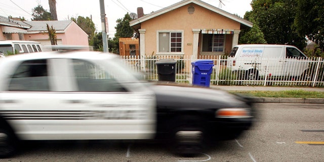 MAYWOOD, CA - MAY 17: A police car drives down a residential street marked to be dug up for service with shorthand letters for "underground service alert" on May 17, 2006 in the Los Angeles-area city of Maywood, California. According to reports, the Maywood City Council has declared the municipality a "sanctuary" for illegal immigrants. The city has done away with the police department's traffic division after receiving complaints that officers were targeting illegal immigrants which has made it more difficult for police to tow cars whose owners do not have driver's licenses. The city also officially opposed a proposed federal law that would have criminalized illegal immigration and forced local police to enforce immigration law. Approximately 96 percent of the city's population of about 29,000 is Latino and more than half are foreign-born. (Photo by David McNew/Getty Images)
