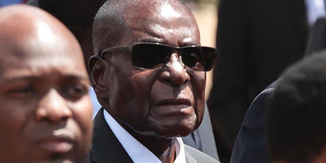 FILE - In this April 12, 2017 file photo, Zimbabwean President Robert Mugabe, centre, attends the burial of a former liberation war hero in Harare, Zimababwe. Mugabe is denying his country is in a fragile state and insists it is one of Africa's most developed despite its plunging economy. The 93-year-old was speaking Thursday, May 4, 2017 at the Africa leg of the World Economic Forum. (AP Photo/Tsvangirayi Mukwazhi, File)