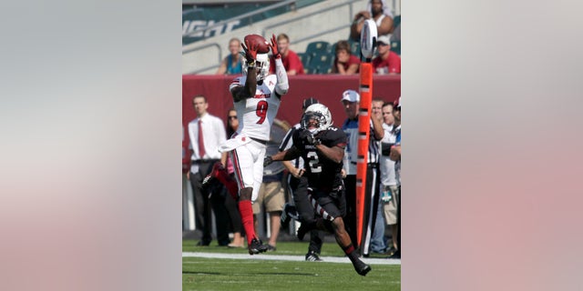Louisville's DeVante Parker (9) makes a reception for a first down as Temple's Anthony Robey (2) defends in the first half of an NCAA college football Game, Saturday Oct. 5 , 2013, in Philadelphia. (AP Photo/H. Rumph Jr)
