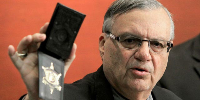 December 21, 2011: Maricopa County Sheriff Joe Arpaio shows his badge as he holds a ceremony where 92 of his immigration jail officers, who lost their federal power to check whether inmates are in the county illegally, turn in their credentials after federal officials pulled the Sheriff's office immigration enforcement powers in Phoenix.