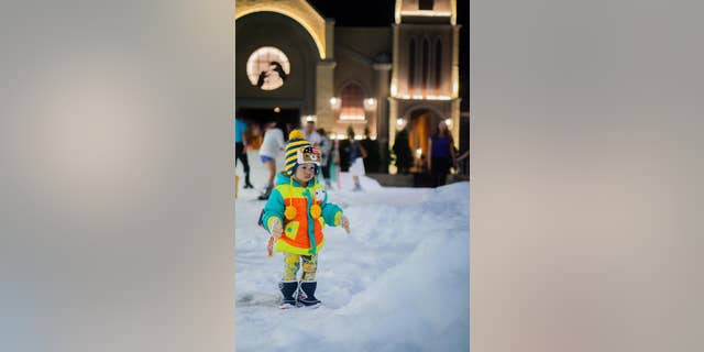 A child looks bewildered in the snowy play area.