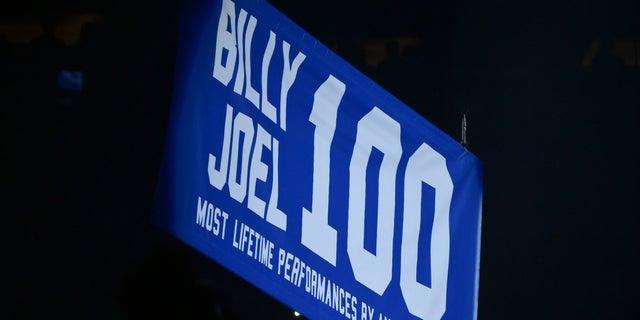 A banner celebrating Billy Joel’s 100th performance was raised at Madison Square Garden.