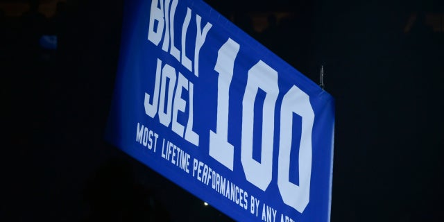 A banner celebrating Billy Joel’s 100th performance was raised at Madison Square Garden.