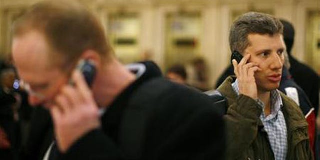 Two men talk on cell phones inside Grand Central Station in New York in this March 4, 2008, file photo. (Reuters Photo)
