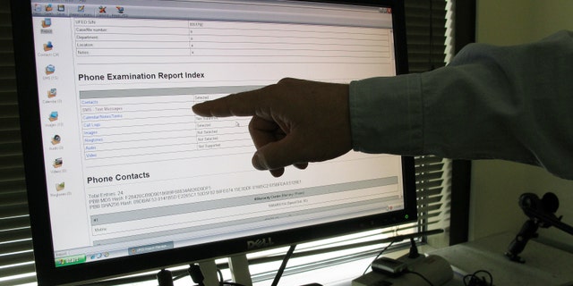 FILE - In this July 18, 2011, file photo, an examiner at an FBI digital forensics lab views data extracted easily from a smartphone, in Salt Lake City. (AP Photo/Lynn DeBruin, File)