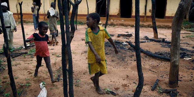 In this April 15 2014 picture, children walk through the burned  Muslim district in the Western Central African town of Guen, Central African Republic. (AP)