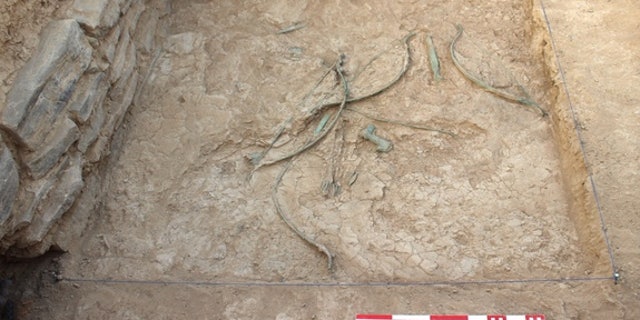 Bows, arrows, daggers and axes scattered on the ground at Mudhmar East, located on the coast of the Arabian Peninsula.