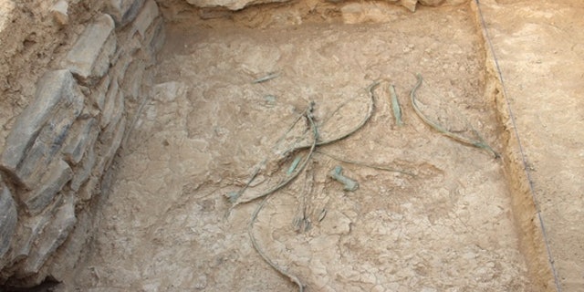 Bows, arrows, daggers and axes scattered on the ground at Mudhmar East, located on the coast of the Arabian Peninsula.