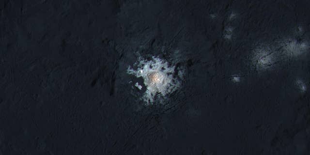 The bright central spots near the center of Occator Crater is shown in enhanced color in this view from NASA's Dawn spacecraft. Such views can be used to highlight subtle color differences on Ceres' surface. (NASA/JPL-Caltech/UCLA/MPS/DLR/IDA/PSI/LPI)