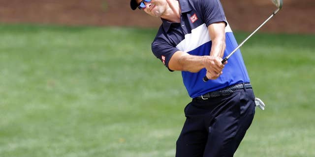 Adam Scott, of Australia, chips to the fourth green during the first round of the Wells Fargo Championship golf tournament at Quail Hollow Club in Charlotte, N.C., Thursday, May 14, 2015. (AP Photo/Bob Leverone)