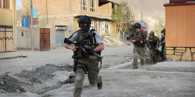 April 15: NATO soldiers run during a gun battle in Kabul, Afghanistan.