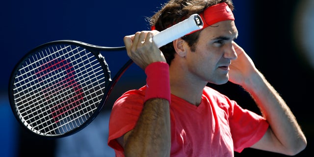 Roger Federer of Switzerland waits to receive serve during a practice session ahead of the Australian Open tennis championship in Melbourne, Australia, Sunday, Jan. 12, 2014.(AP Photo/Eugene Hoshiko)