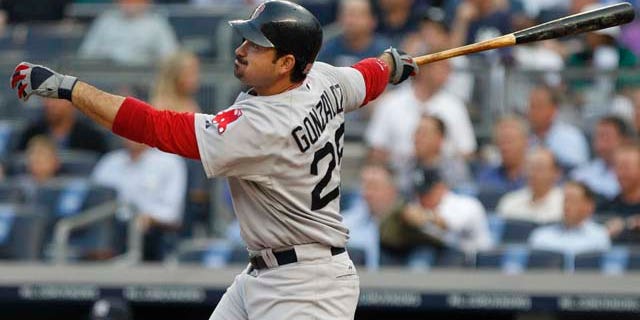 Boston Red Sox's Adrian Gonzalez follows through on an RBI triple during the first inning of a baseball game ,Tuesday, June 7, 2011, at Yankee Stadium in New York. (AP Photo/Frank Franklin II)