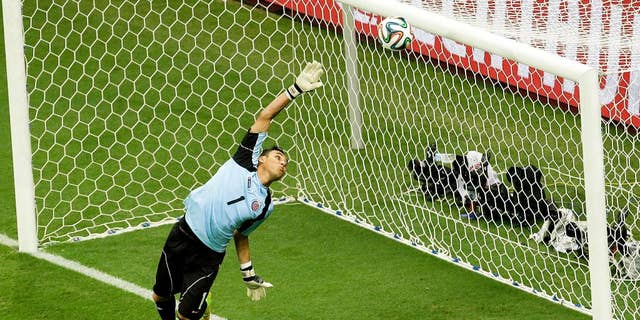 Costa Rica's goalkeeper Keylor Navas dives as the ball hits the bar during the World Cup quarterfinal soccer match between the Netherlands and Costa Rica at the Arena Fonte Nova in Salvador, Brazil, Saturday, July 5, 2014. (AP Photo/Themba Hadebe)
