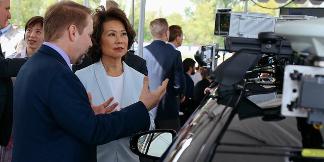 U.S. Transportation Secretary Elaine Chao looks at autonomous vehicle technology after announcing new voluntary safety guidelines for self-driving cars during a visit to an autonomous vehicle testing facility, Tuesday, Sept. 12, 2017, at the University of Michigan, in Ann Arbor, Mich. The new guidelines update policies issued last fall by the Obama administration, which were also largely voluntary. (Hunter Dyke/The Ann Arbor News via AP)